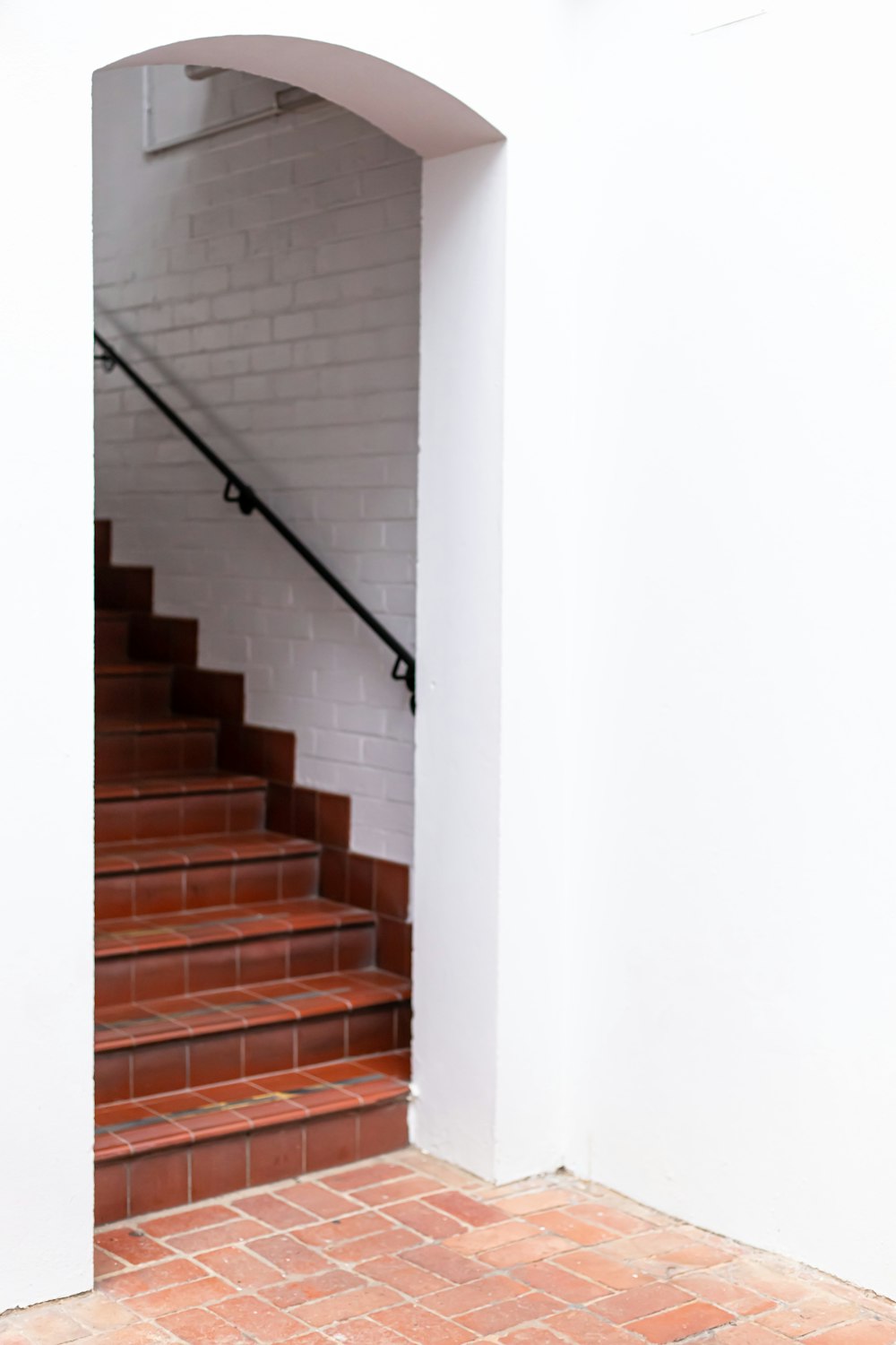 brown and white staircase with black railings