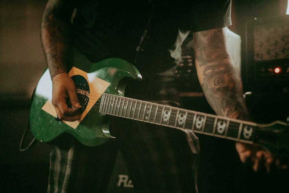 man in black t-shirt playing electric guitar