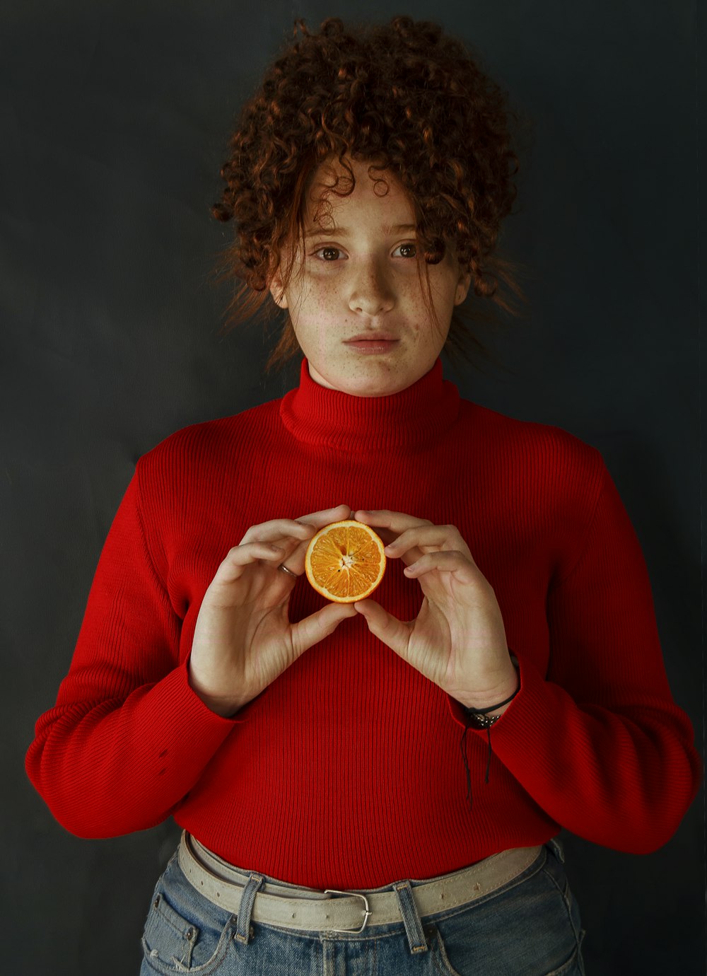 donna in camicia rossa a maniche lunghe che tiene moneta rotonda d'oro