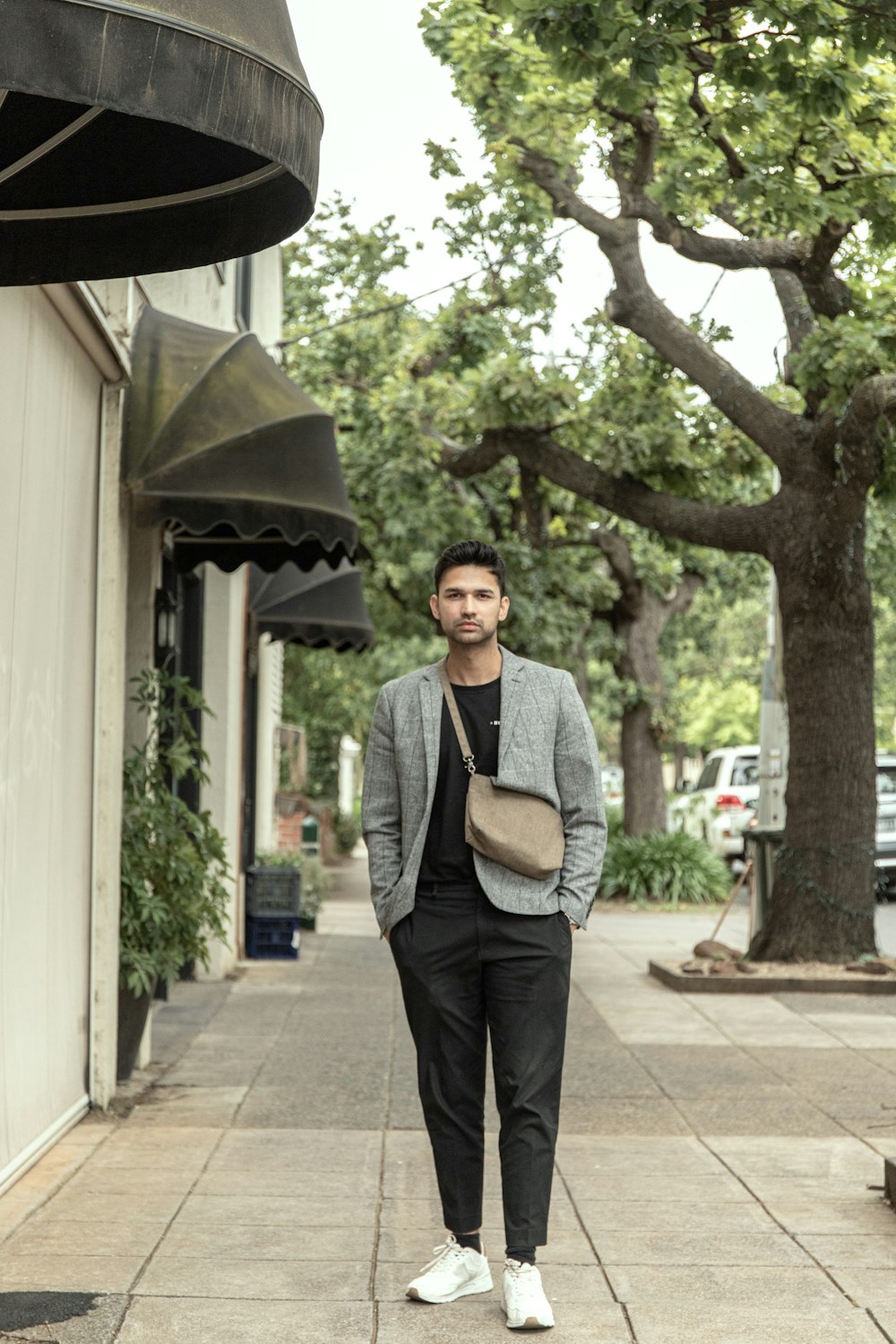 man in gray vest standing near tree during daytime