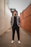 man in gray suit jacket and black pants standing on brown concrete pathway during daytime