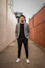 man in gray suit jacket and black pants standing on brown concrete pathway during daytime
