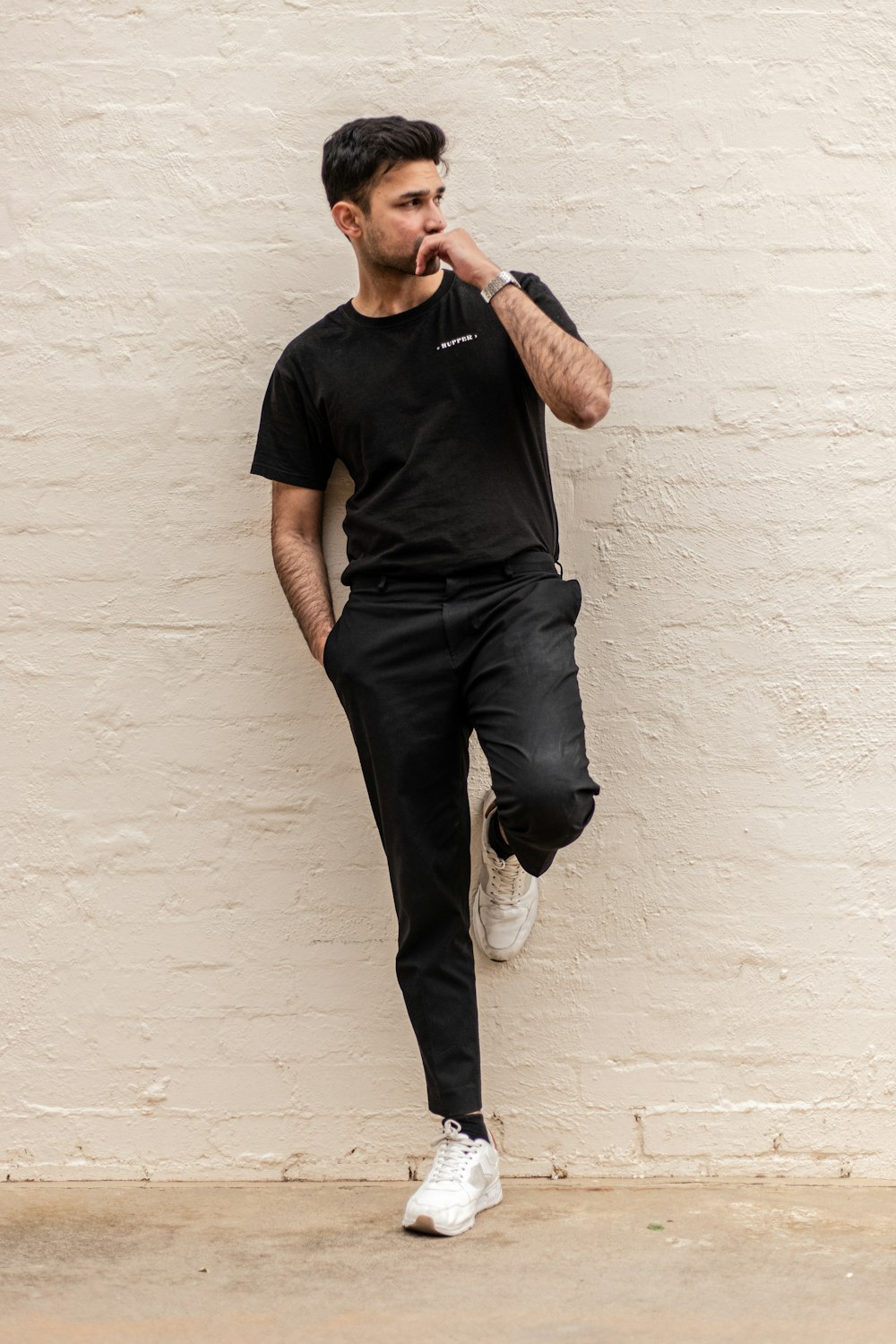 Man in black crew neck t-shirt and blue denim jeans leaning on white wall  photo – Free Black Image on Unsplash