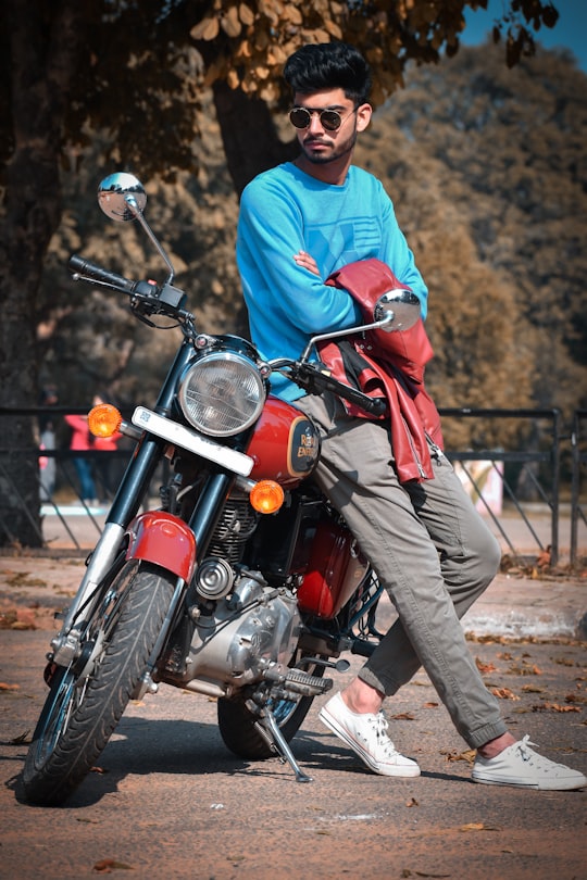 man in red jacket and gray pants riding red motorcycle in Chandigarh India