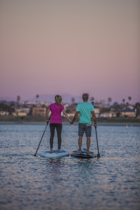 man and woman standing on blue and white boat on sea during daytime