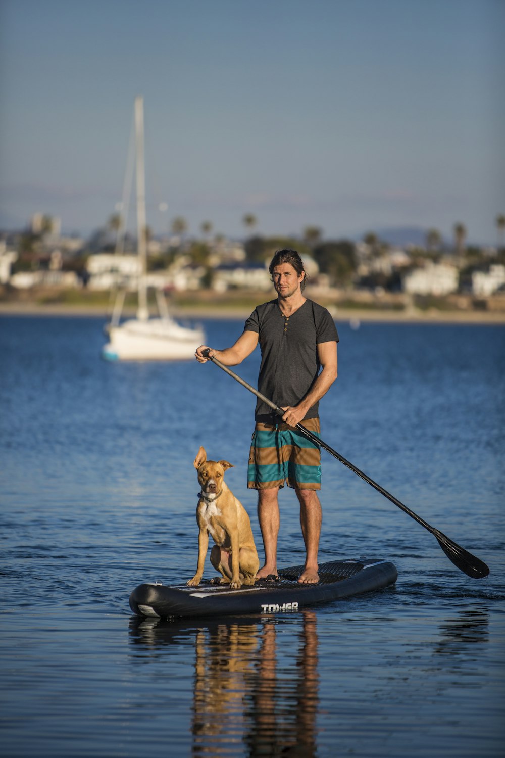 man in blue polo shirt and black pants riding on black boat during daytime