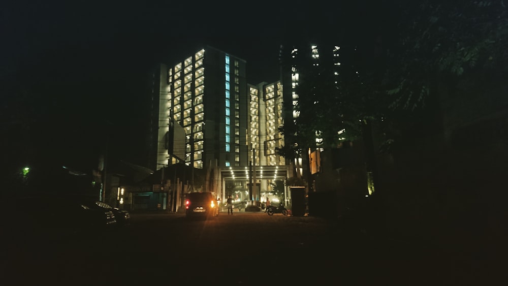 cars on road near high rise buildings during night time