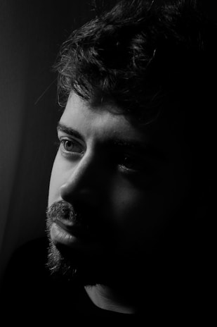 An artistic black and white portrait of a thoughtful man.