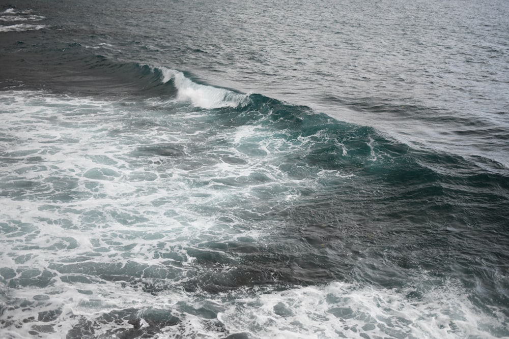 ocean waves crashing on shore during daytime