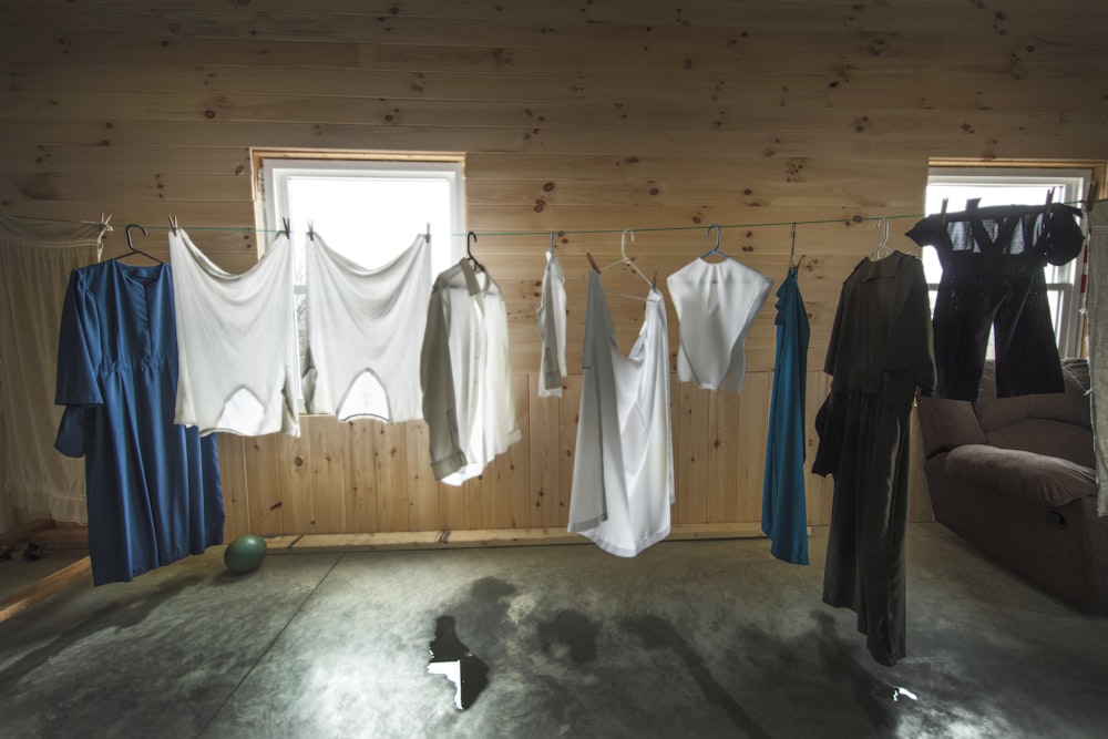 white dress shirt hanged on brown wooden cabinet