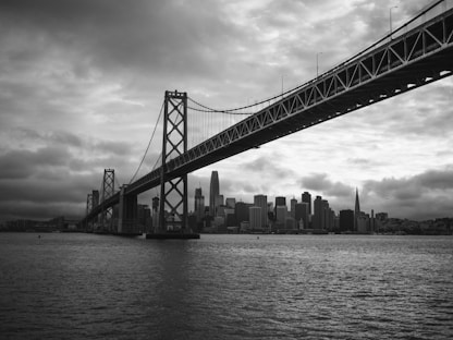 grayscale photo of bridge over body of water