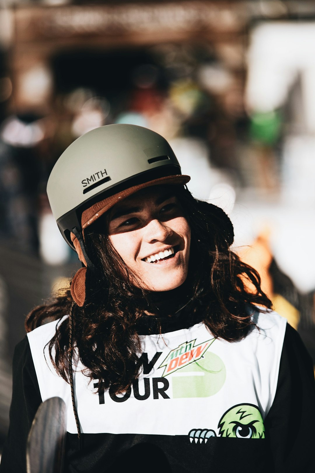 smiling woman in white shirt wearing black helmet