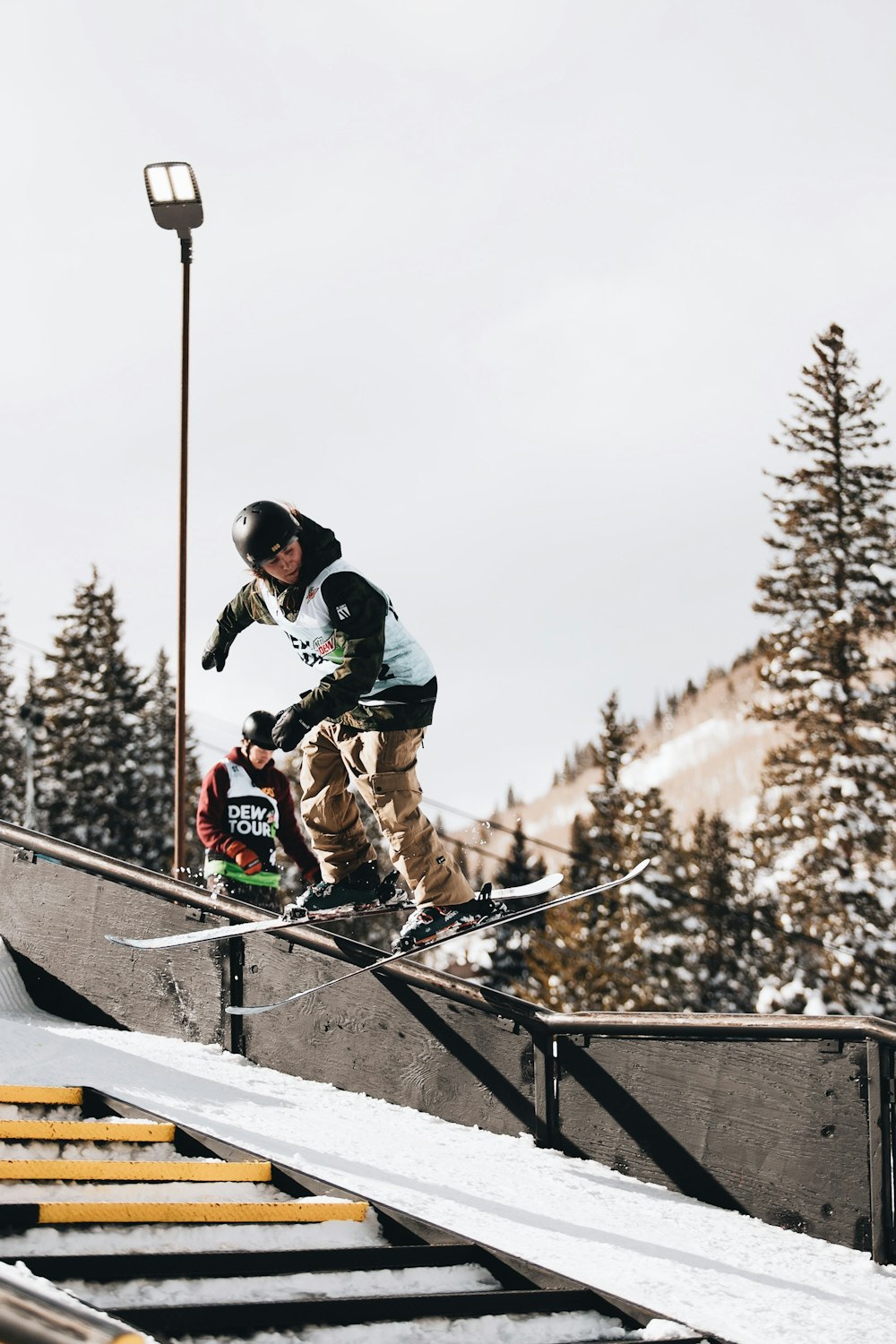 man in black jacket and black pants riding on black and white ski blades during daytime