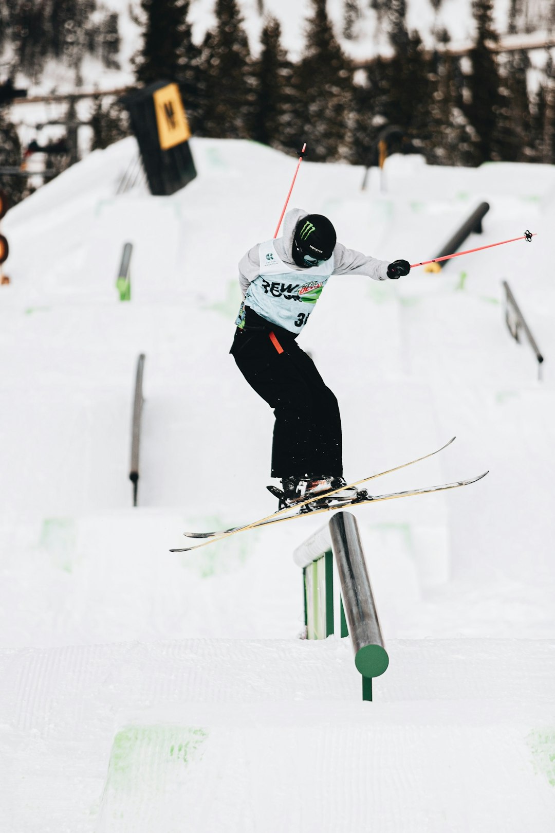 person in white and black jacket and black pants riding ski blades on snow covered field