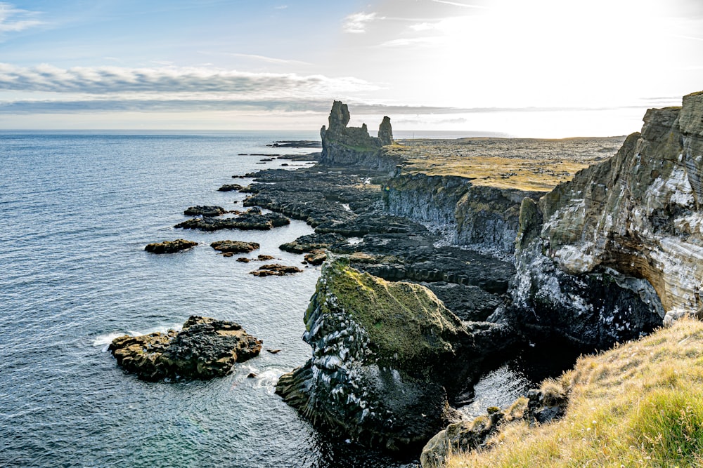 green and gray rock formation on sea during daytime