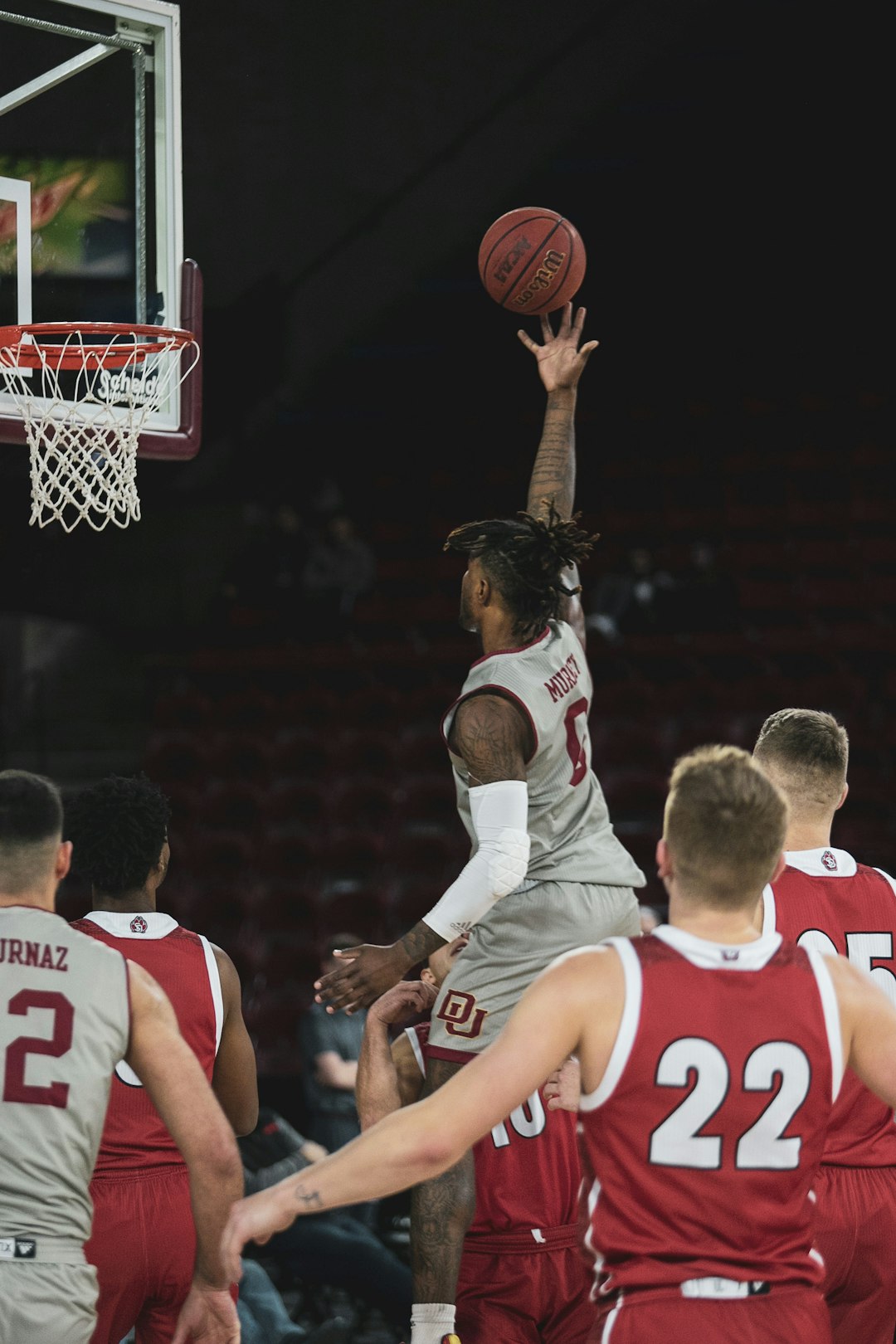 2 men in white and red jersey shirt playing basketball