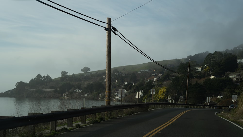 gray concrete road near green trees during daytime