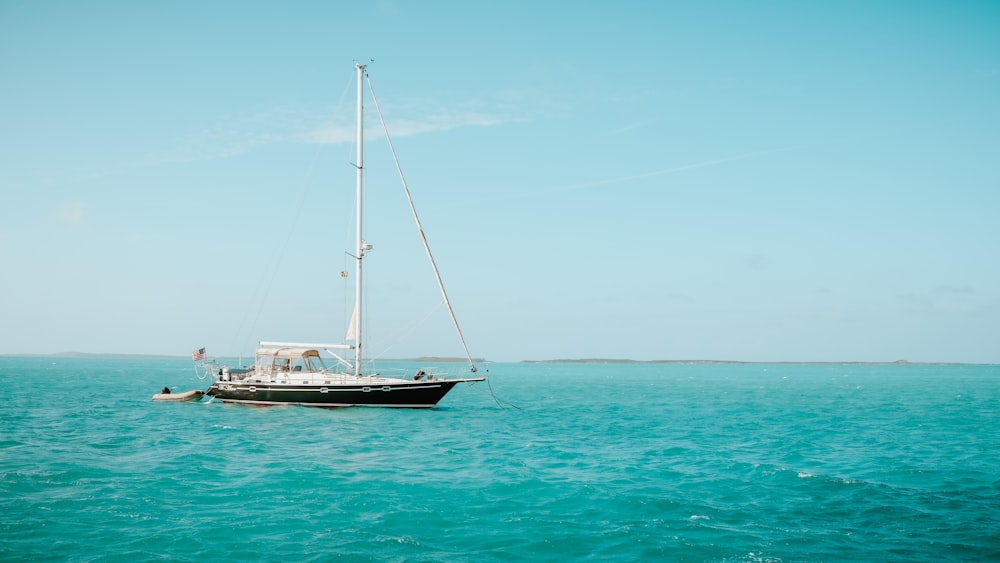 white and blue boat on sea under blue sky during daytime