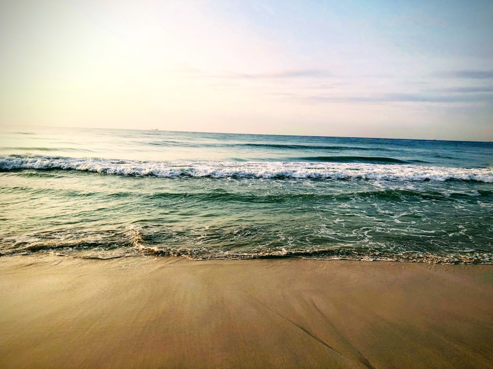 ocean waves crashing on shore during daytime