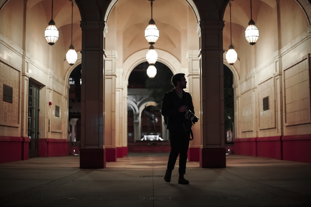 man in black coat standing on hallway