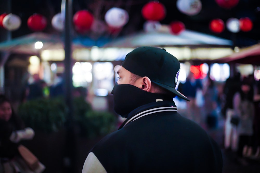 man in black and white shirt wearing black cap