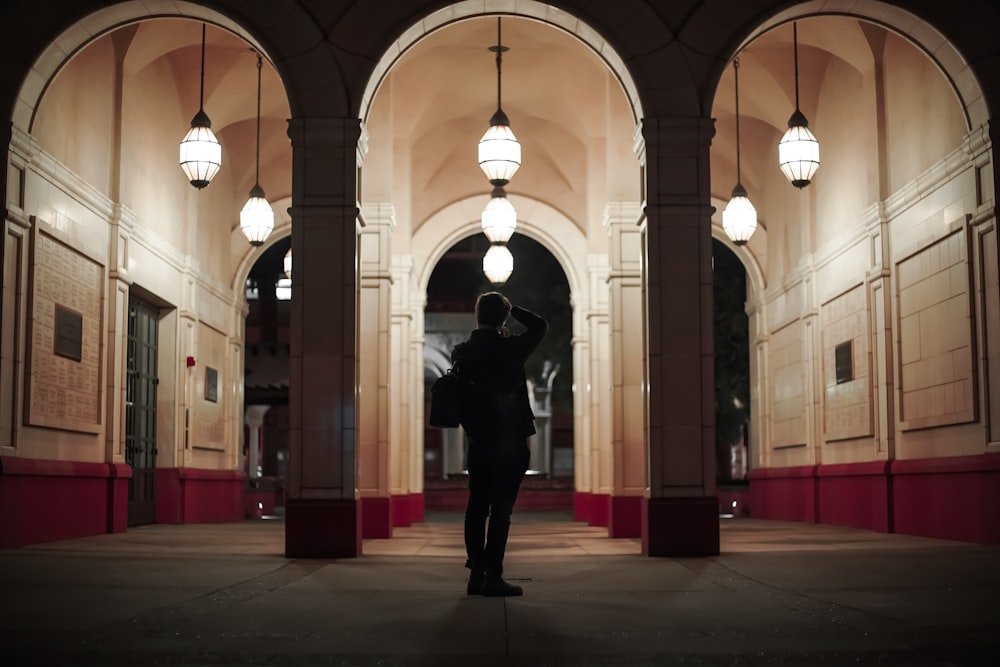 man in black jacket standing on hallway