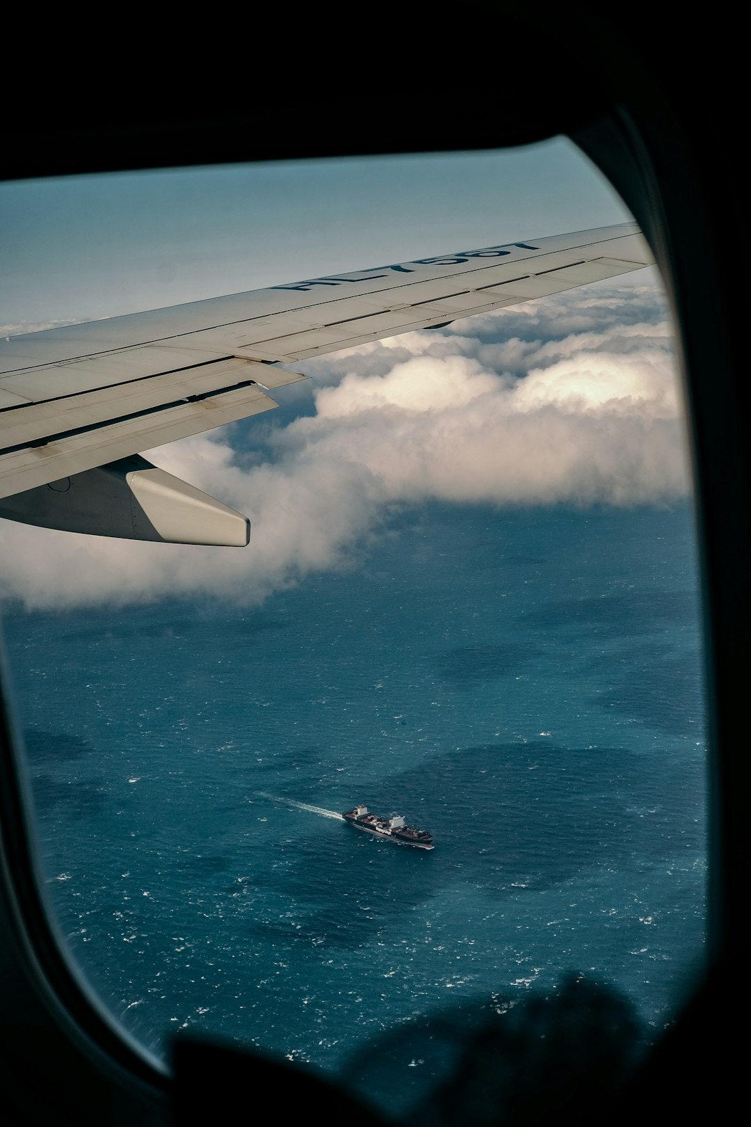 white and black airplane wing over blue sea