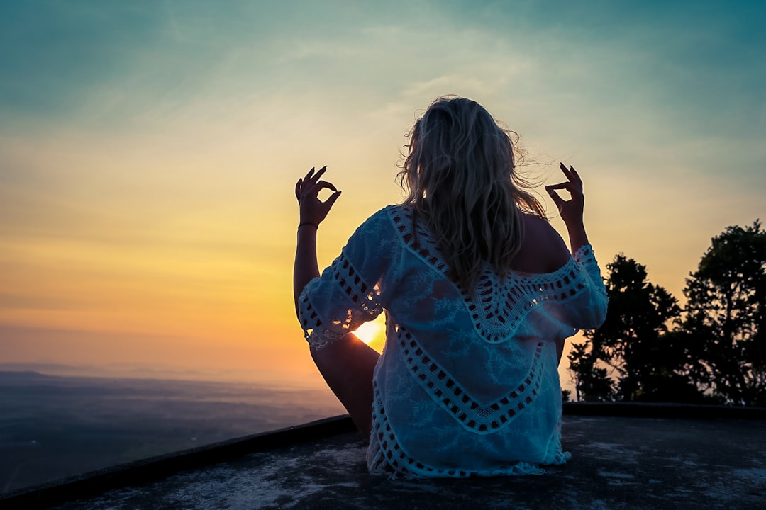 woman in blue and white floral dress standing on beach during sunset