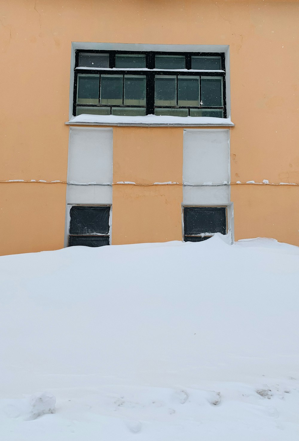 orangefarbenes Betongebäude mit schwarzem Fensterrahmen