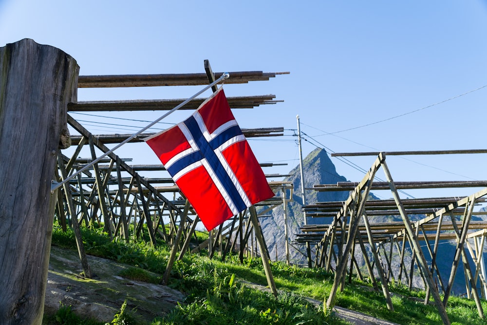 bandeira vermelha branca e azul no mastro de madeira marrom durante o dia