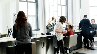 woman in gray sweater and black pants standing in front of mirror