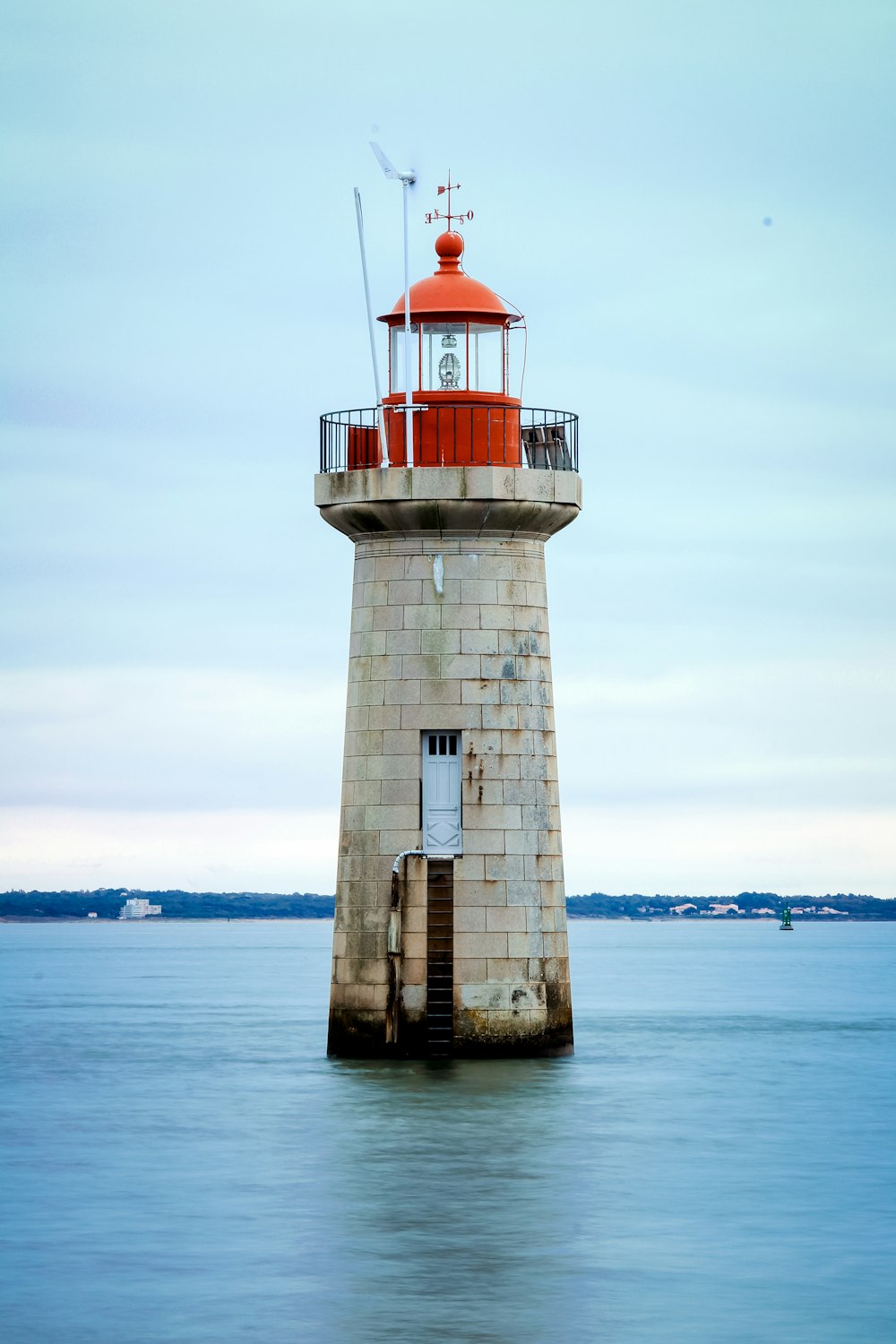 white and red lighthouse on body of water during daytime