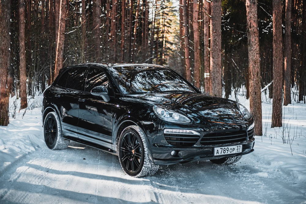 black mercedes benz c class parked on snow covered ground