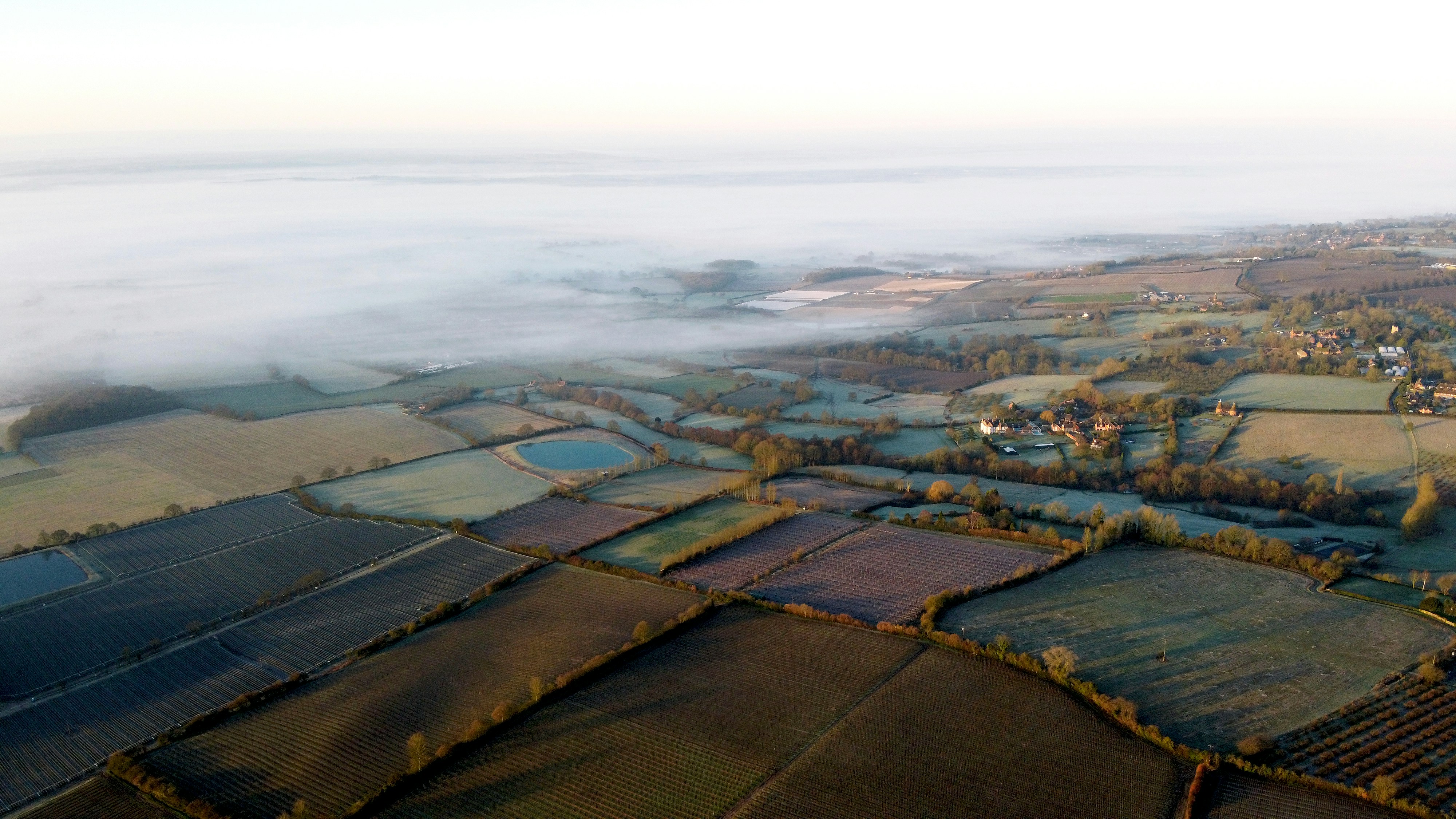 aerial view of green field under cloudy sky during daytime