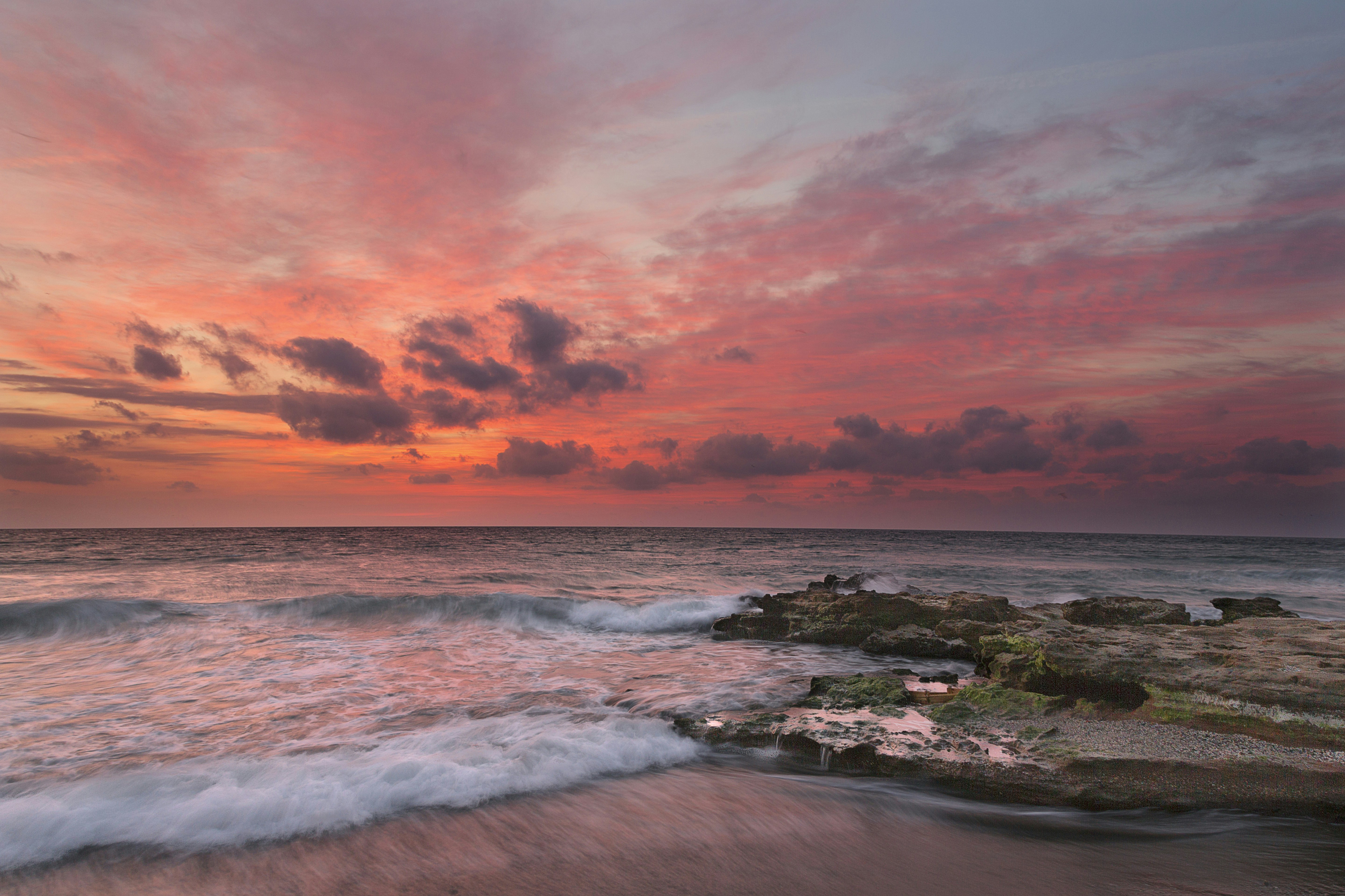 ocean waves crashing on shore during sunset
