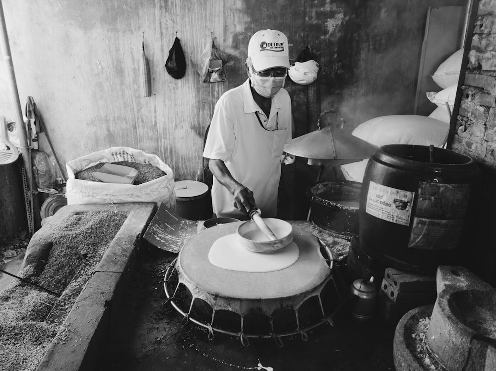 man in white chef uniform holding knife and fork in grayscale photography