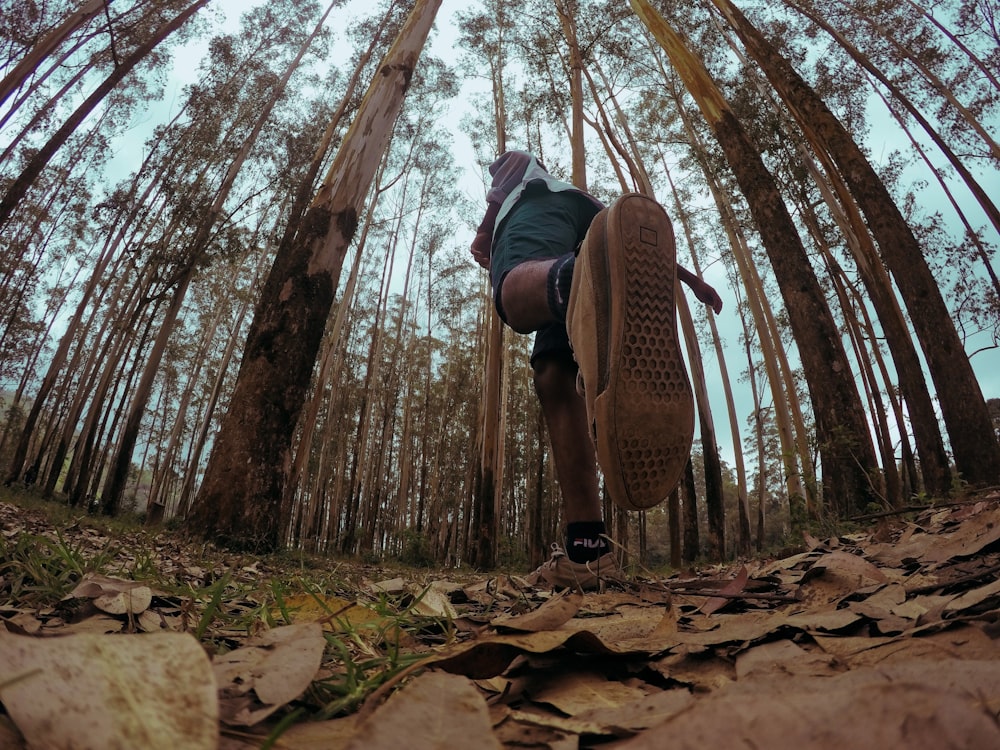 woman in black jacket and brown pants sitting on brown tree branch during daytime