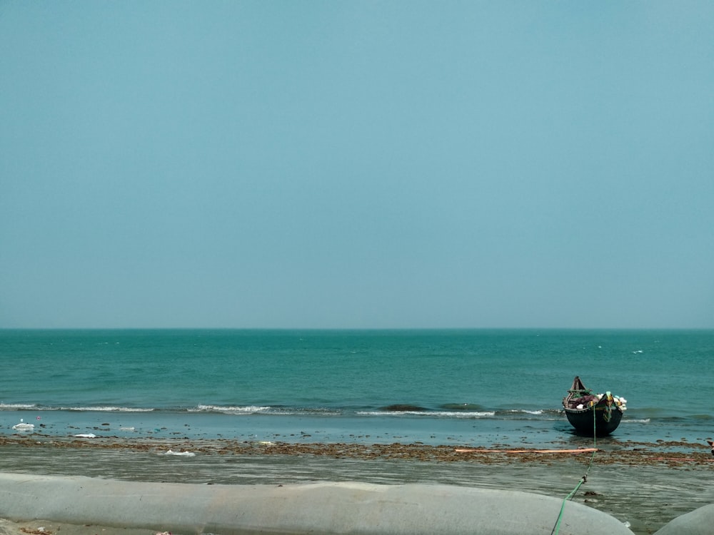 homme en chemise noire équipant un bateau sur la mer pendant la journée