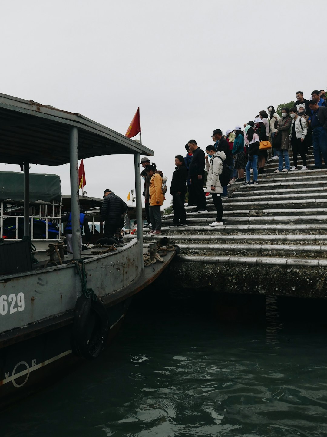 people standing on gray concrete dock during daytime