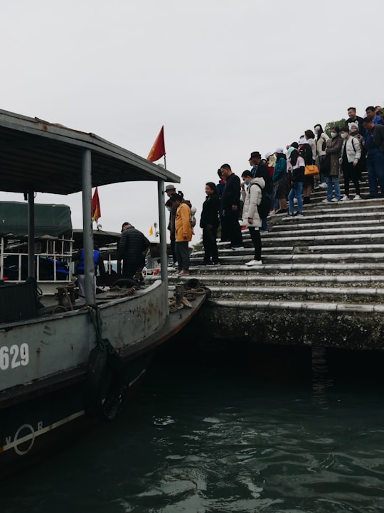 people standing on gray concrete dock during daytime in Halong Bay Vietnam