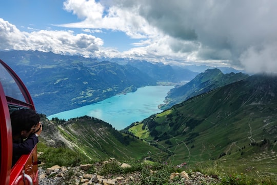 green mountains under white clouds and blue sky during daytime in Lake Brienz Switzerland
