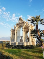 white concrete building near green trees under blue sky during daytime