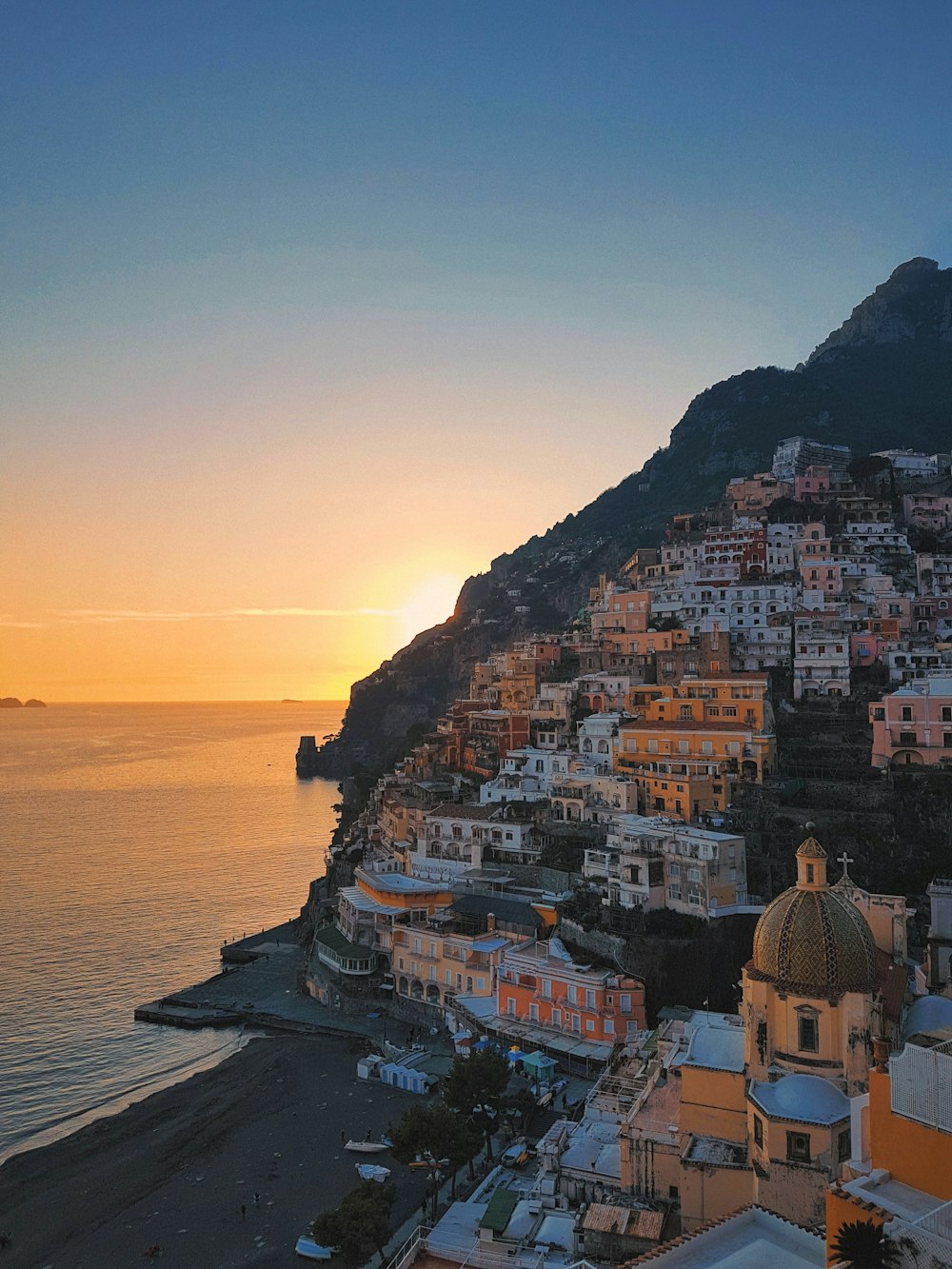 houses on mountain near body of water during daytime