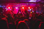 people standing on stage with lights turned on during nighttime