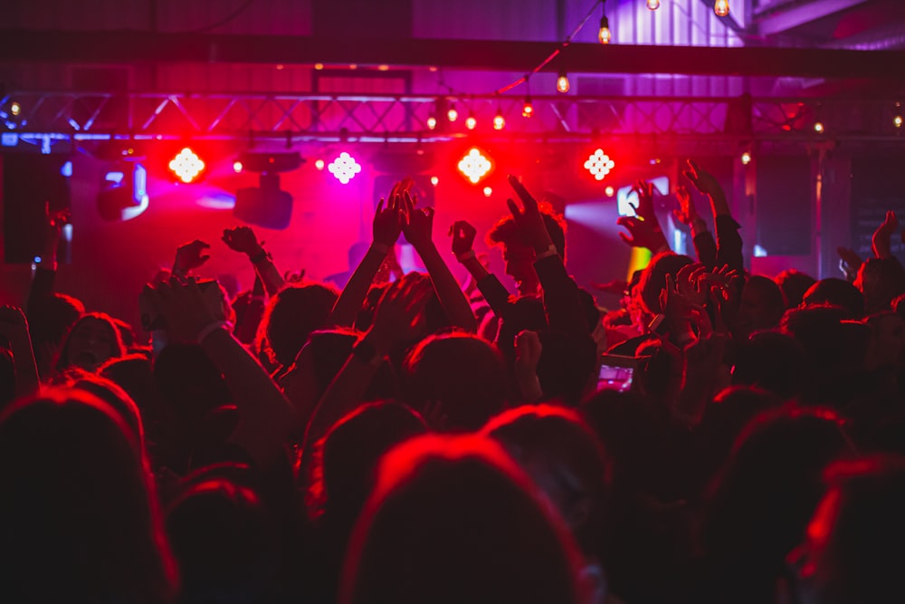 people standing on stage with lights turned on during nighttime