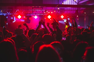 people standing on stage with lights turned on during nighttime