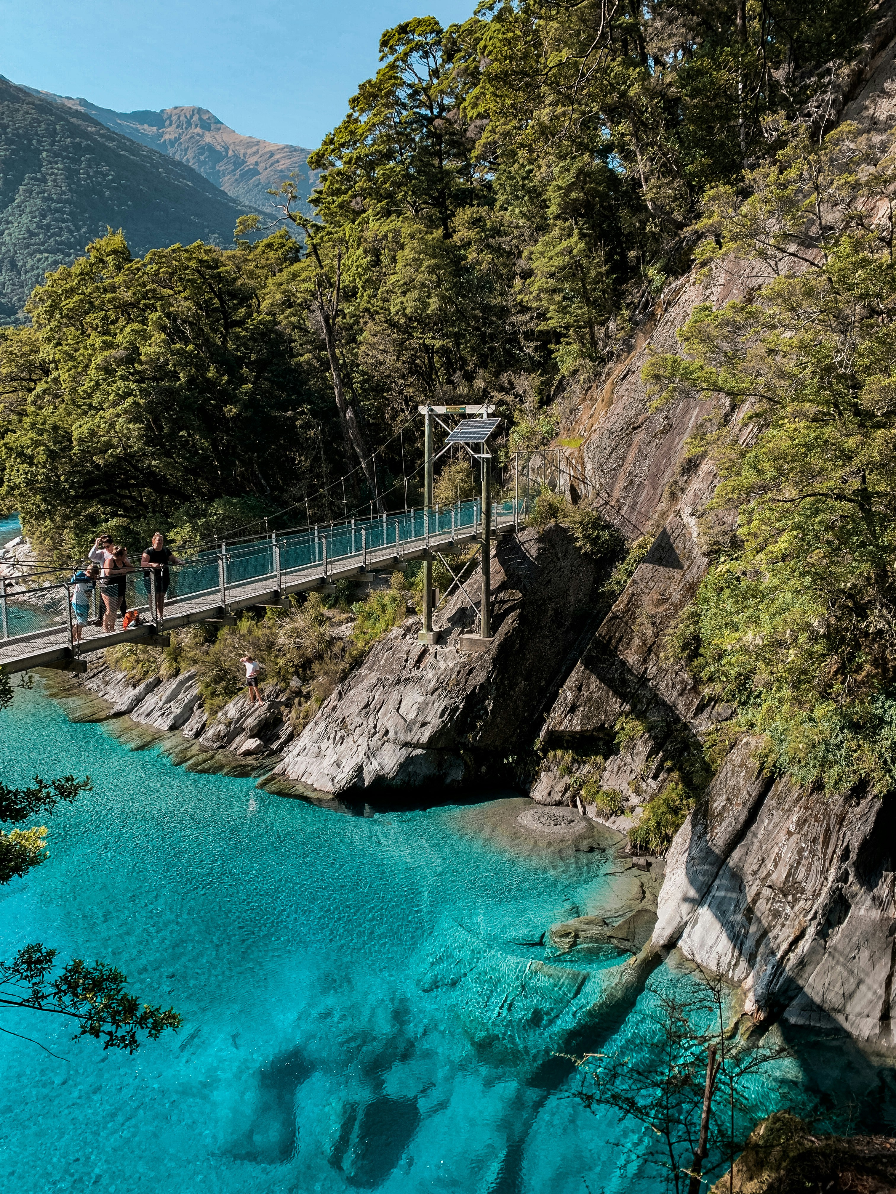 people walking on bridge over river during daytime