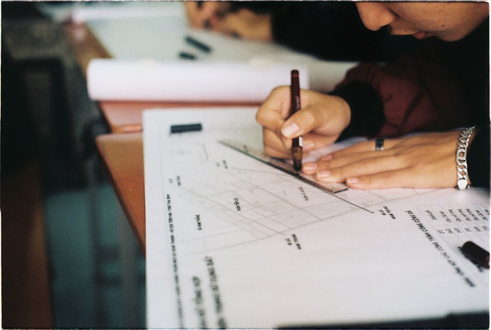 person writing on white paper