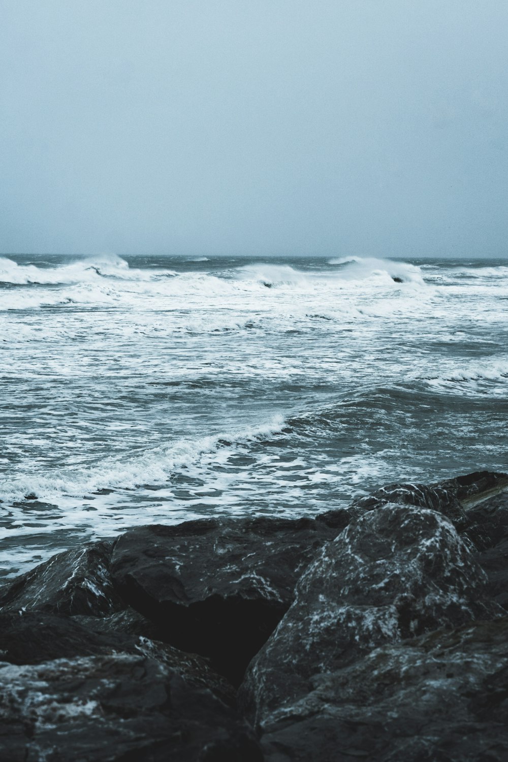 ocean waves crashing on rocks during daytime