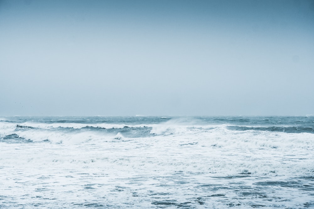 ondas do oceano sob o céu azul durante o dia